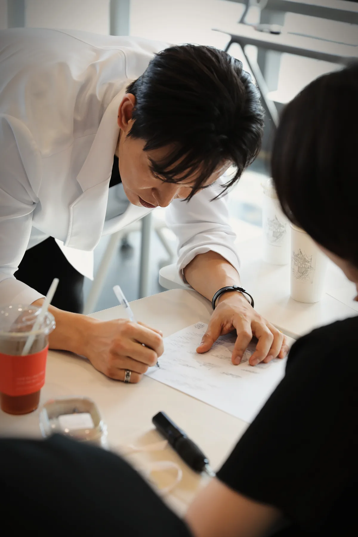 대표원장이 수강생 옆에서 종이에 직접 적으며 설명하는 모습